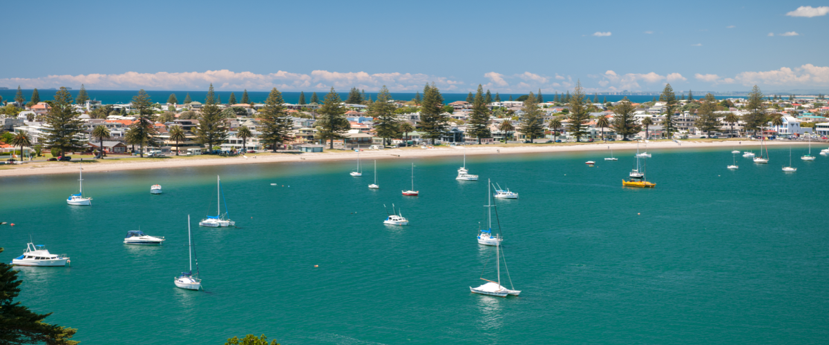 Turquoise harbour with sailboats and Norfolk pines along Mount Maunganui waterfront — The Gold House® silver bars, New Zealand