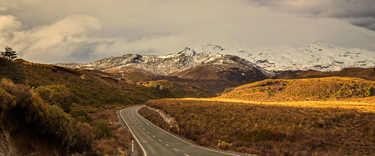 The Gold House® — New Zealand high country road Scenic mountain road through New Zealand high country at golden hour — The Gold House® bullion and treasury building, New Zealand
